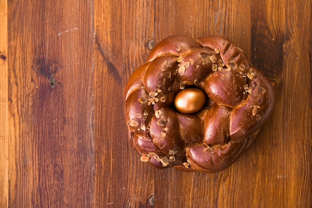 Tsoureki tradicional pão doce de páscoa grego, guarnecido com amêndoas lascadas e decorado com um ovo tingido de vermelho cozido no meio