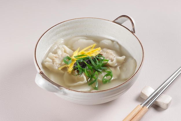 Tteok Mandu Guk ist eine koreanische Reiskuchensuppe mit Knödeln in Rinderbrühe.