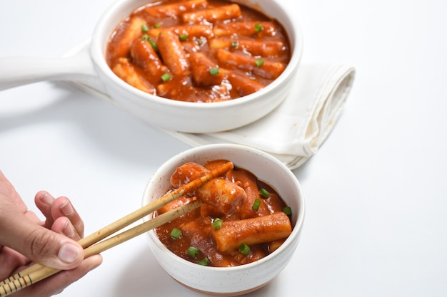 Foto tteokbokki oder koreanischer würziger reiskuchendas bild von köstlichen würzigen tteokbokki auf weißem hintergrund