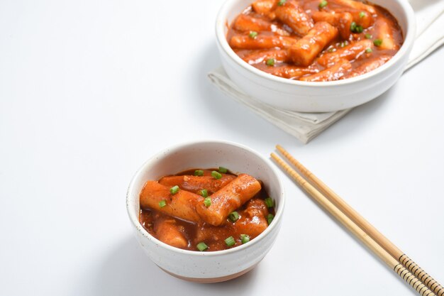 tteokbokki ou bolo de arroz picante coreano A imagem de um delicioso tteokbokki picante no fundo branco