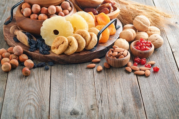 Tu Bishvat Feierkonzept Mischung aus Trockenfrüchten und Nüssen Mandeln Haselnüsse Walnüsse Aprikosen Pflaumen Kirschen Rosinen Datteln Äpfel Feigen über Holztisch Jüdischer Feiertag Neujahr der Bäume