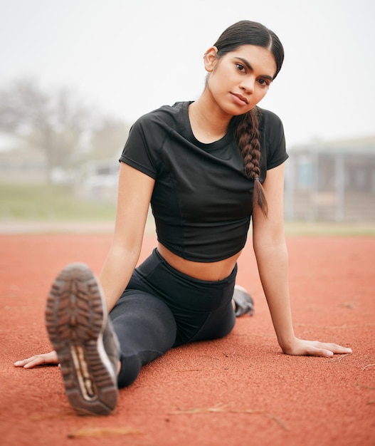 Tu cuerpo puede hacer grandes cosas si se lo permites Fotografía de una joven atlética estirándose en la pista