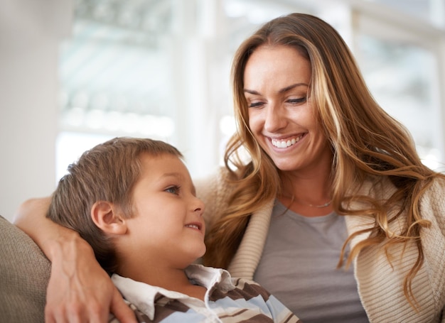 Tu madre es tu primera mejor amiga Un niño y su madre se unen felizmente mientras están sentados en un sofá