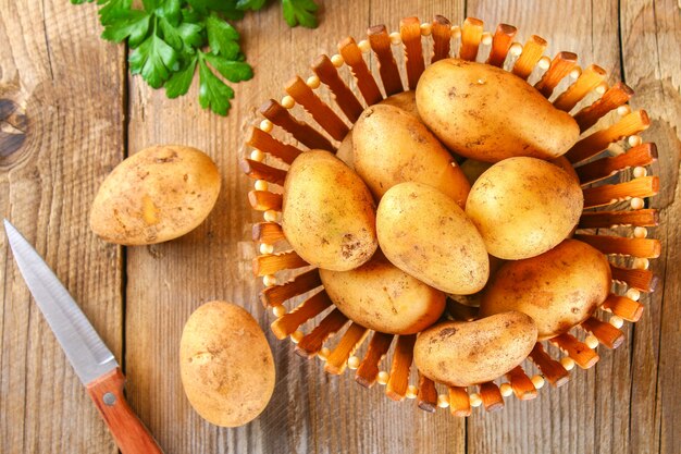 Tubérculos amarillos de la patata en una tabla de madera vieja.