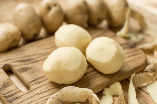 Tubérculos crudos patatas peladas sobre un fondo de madera