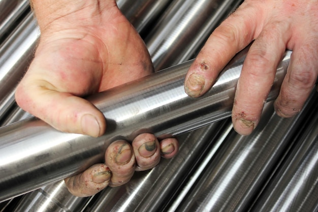 Foto tubería de acero y manos de los trabajadores