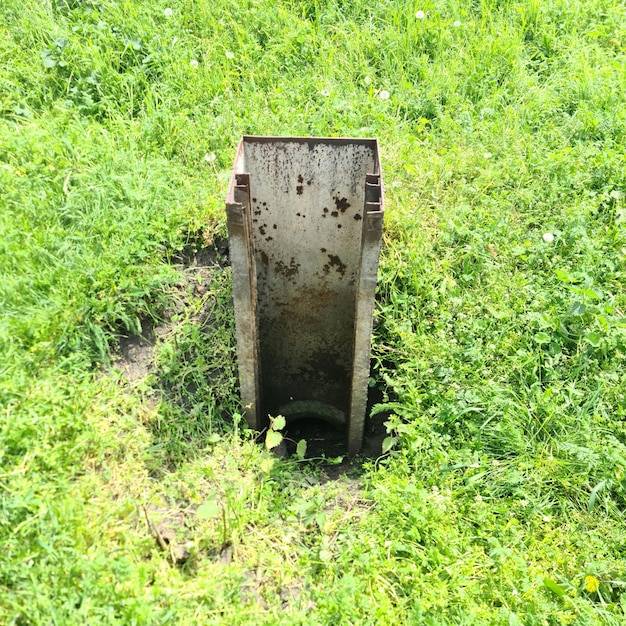 Una tubería de agua está en la hierba y tiene la palabra agua.