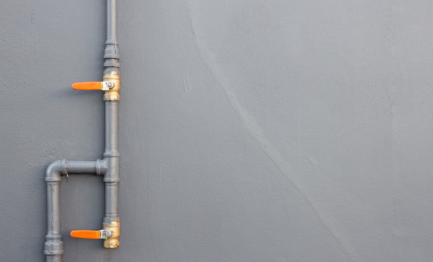 La tubería de agua del primer instala en fondo de la pared de ladrillo