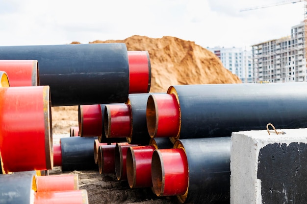 Tubería aislada Grandes tuberías de metal con una funda de plástico en un sitio de construcción Tubería moderna para el suministro de agua caliente y calefacción a una zona residencial