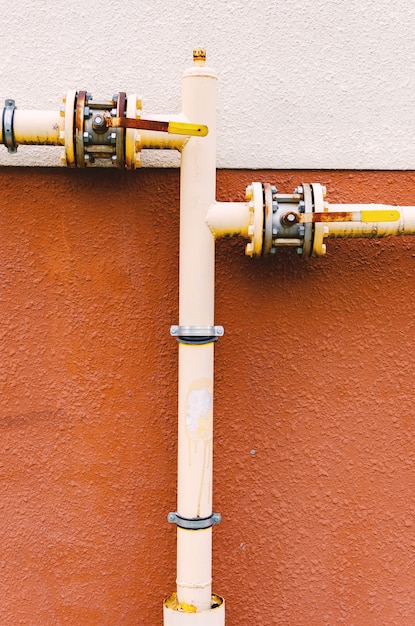 La tubería de gas amarilla con una grúa recorre la fachada de un nuevo edificio de varios pisos.