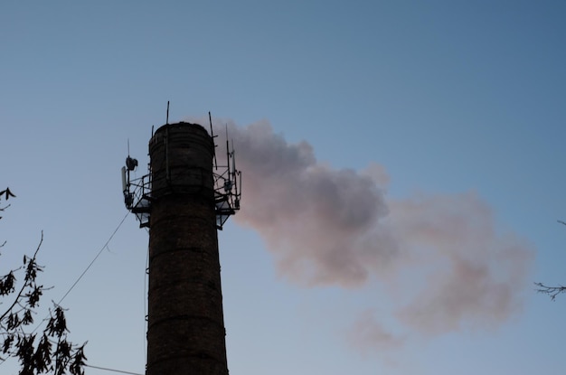 Tubería industrial y humo contra el cielo. Contaminación ambiental