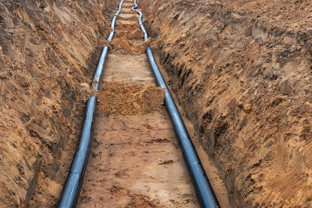 Las tuberías de agua para el suministro de agua potable se encuentran en el sitio de construcción Preparación para movimientos de tierra para colocar una tubería subterránea Sistemas modernos de suministro de agua para una ciudad residencial