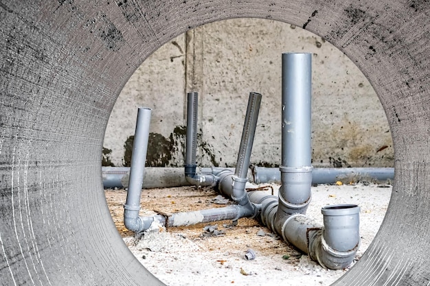 Foto tuberías de alcantarillado en el sótano de la casa sistema de tuberías sanitarias grises al construir una casa instalación de alcantarillado para la eliminación de aguas residuales