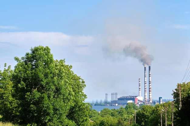 Tuberías altas de la planta de energía de carbón con humo negro moviéndose hacia arriba contaminando la atmósfera. Producción de energía eléctrica con concepto de combustibles fósiles.