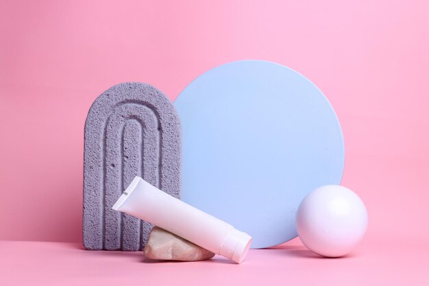 Tubo cosmético com várias formas geométricas Modelo de apresentação para produtos de beleza em fundo rosa