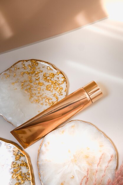 Foto tubo cosmético dorado en color pastel minimalismo belleza