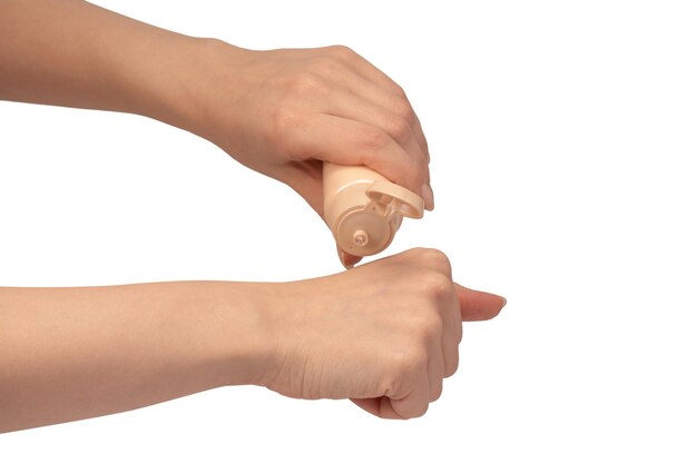 Tubo de crema beige en las manos de la mujer aislado sobre un fondo blanco Muestra de crema en la mano de la mujer