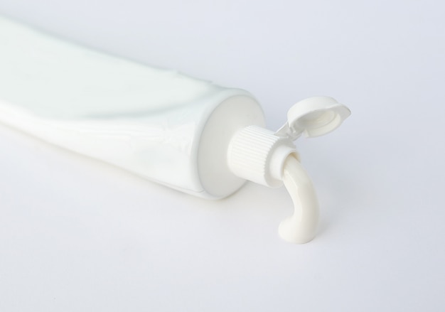 Tubo de crema dental o crema sobre fondo blanco.