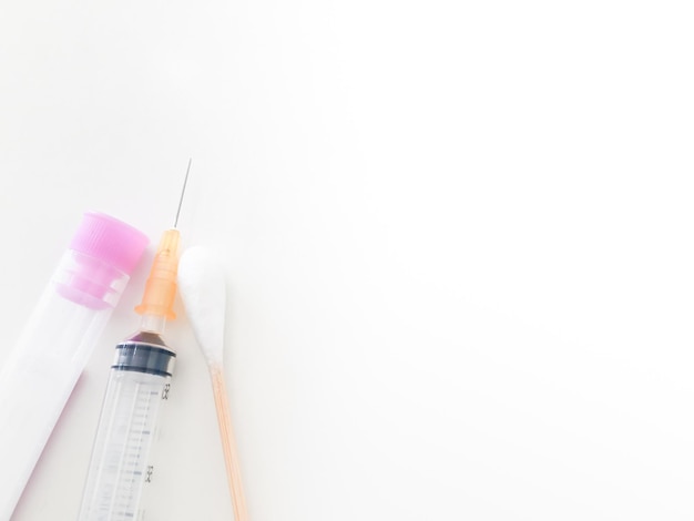 Tubo de colheita de sangue e seringa e cotonete com espaço para cópias no conceito de controlo de cuidados de saúde
