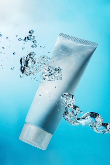 Tubo de creme em água azul com bolhas no tanque Copiar o conceito cosmético hidratante do espaço