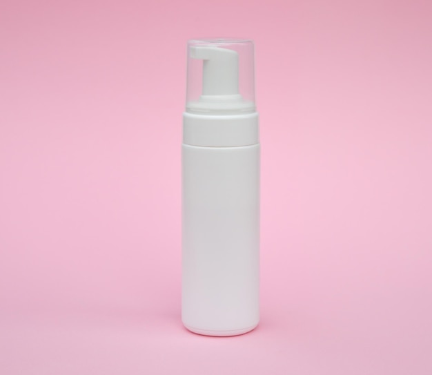 Tubo de embalagem branco vazio para cuidados com a pele médica de spa de beleza e embalagem de creme de loção cosmética layout de design de produto de espuma de lavagem de rosto em fundo rosa