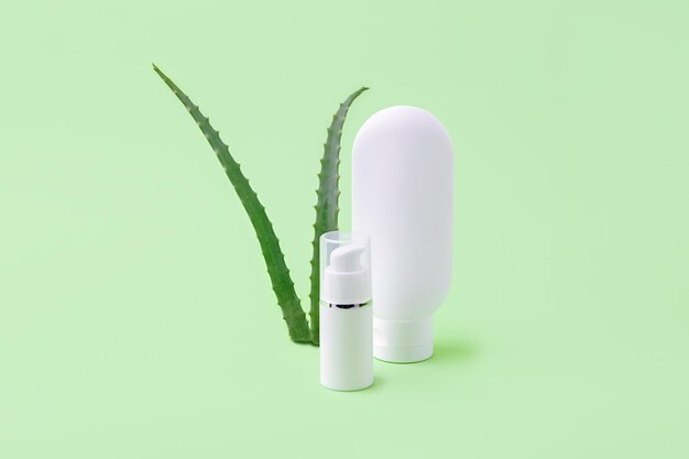 Tubo y dispensador de cosméticos en blanco con aloe vera sobre fondo Concepto cosmético orgánico