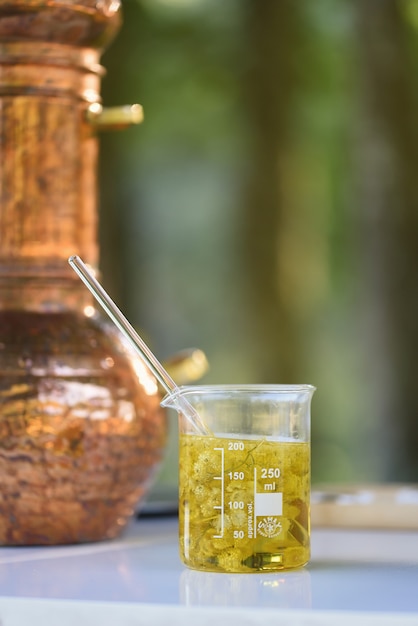 Foto tubo de ensayo con aceite esencial mezclado con flores y fondo fijo