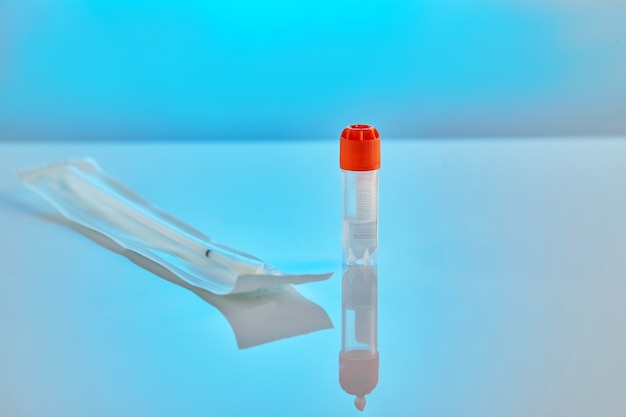Foto tubo de ensayo con líquido para análisis de adn y una barra en un paquete