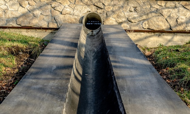 Un tubo de hormigón es visible frente a un muro de piedra.