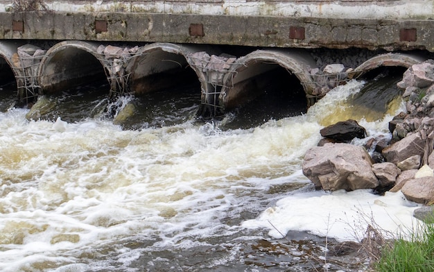 Un tubo de hormigón que transporta aguas residuales contaminadas malolientes en el río a través de la contaminación de las tuberías de la en