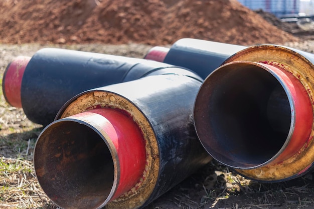 Tubo isolado Grandes tubos de metal com bainha de plástico em um canteiro de obras Tubulação moderna para fornecimento de água quente e aquecimento para uma área residencial Closeup