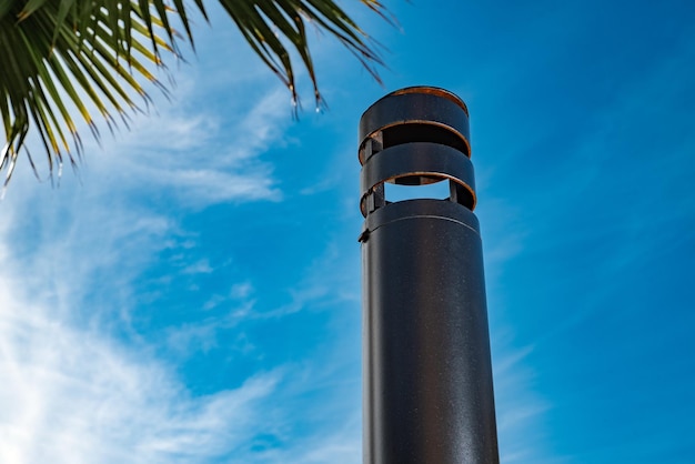 Foto tubo de metal contra el cielo azul y la palmera