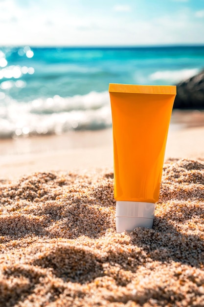 Tubo naranja de protector solar en el fondo de la playa del mar Concepto cosmético de cuidado de la piel de verano Espacio de copia