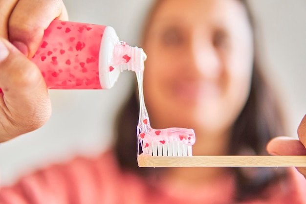 Foto tubo de pasta de dientes de san valentín y cepillo de dientes usado por una dama feliz