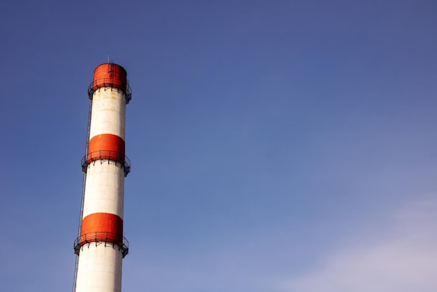 Tubo rojo y blanco de la planta contra el fondo del cielo azul