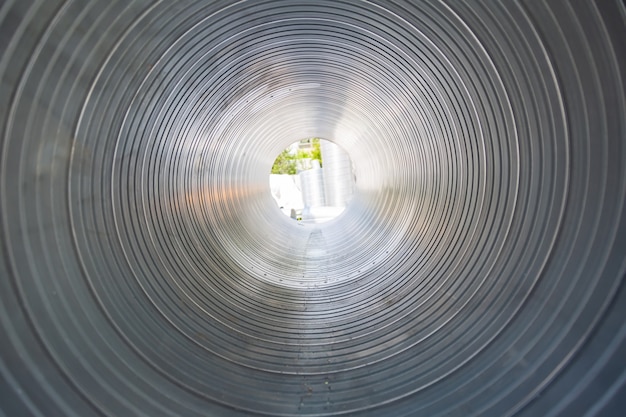 El tubo de ventilación es redondo desde el interior. Tuberías de acero, piezas para la construcción de conductos de aire acondicionado industrial dentro de la tubería. Equipos de ventilación industrial.