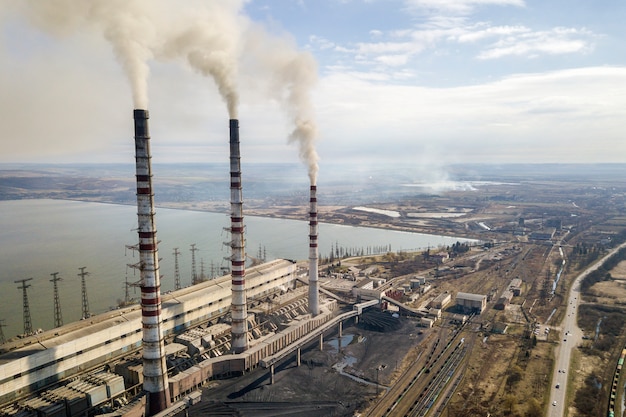 Los tubos altos de la central eléctrica, el humo blanco en el paisaje rural, el agua del lago y el cielo azul copian el fondo del espacio.