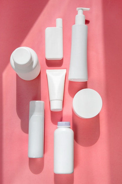 Foto tubos blancos para cosméticos fondo rosa flatley