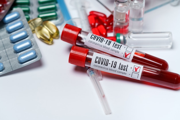 Foto tubos de ensaio de sangue e embalagens de comprimidos e cápsulas de medicamento