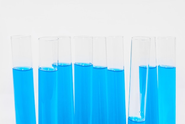 Tubos de ensaio de vidro transparente em um fundo branco elemento químico líquido azul catalisador equipamento médico de laboratório bioquímica de vidro modelo de laboratório químico para medicina