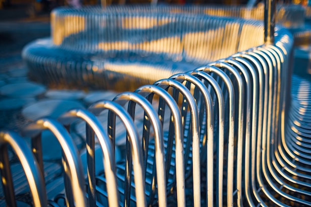 Tubos de metal de banco de rua de close-up dispostos paralelos uns aos outros em uma estrutura de rua. Conceito de materiais resistentes às intempéries e design industrial moderno.