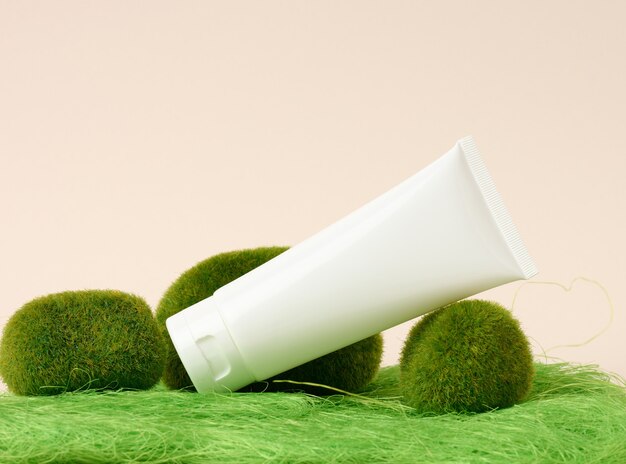 Tubos de plástico brancos vazios para cosméticos em um fundo verde. Embalagem para creme, gel, soro, publicidade e promoção de produto, mock up