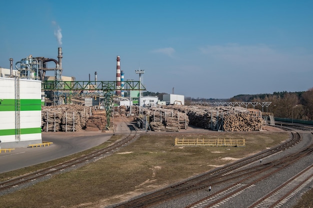 Tubos de serraria de fábrica de marcenaria perto do rio Conceito de poluição do ar Paisagem industrial poluição ambiental resíduos de usina termelétrica