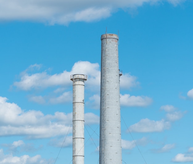 Foto tubos de uma empresa industrial contra um céu azul com nuvens. chaminé sem fumaça