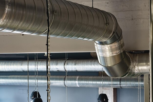 Foto tubos de ventilação prateados pendurados no teto dentro do prédio