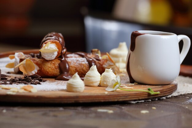 Tubos de wafer com creme e chocolate em uma bandeja de madeira com açúcar de confeiteiro