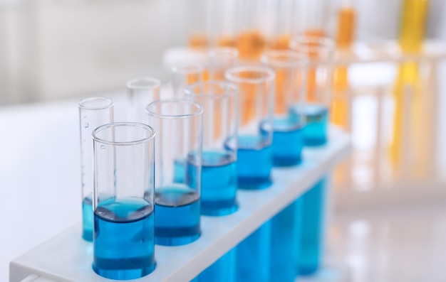 Tubos de ensayo de laboratorio de ciencias con líquido químico azul y naranja
