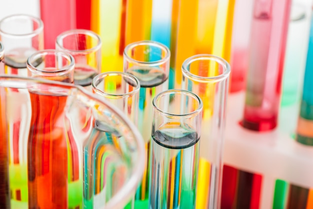 Foto tubos de ensayo con productos químicos coloridos de cerca en laboratorio