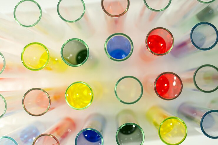 Tubos de ensayo de vidrio con líquidos de colores en la vista superior de fondo blanco