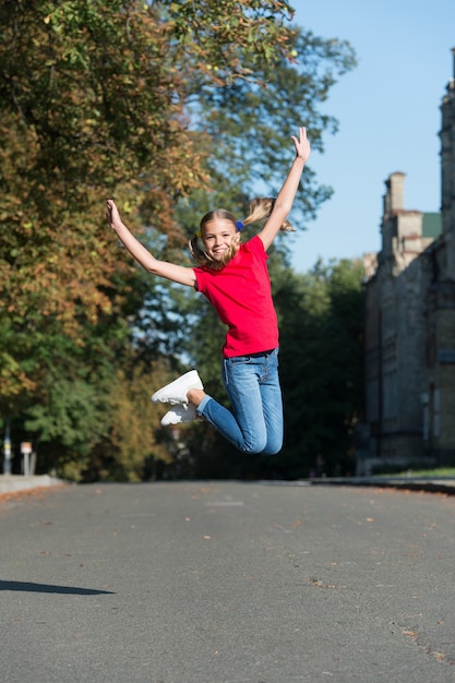 Foto tue mehr von dem, was dich glücklich macht. glückliches kind springt im freien hoch. glückliche kindheit. spaß haben. glückliches kind aufziehen. schulferien. sommerurlaub. internationaler kindertag.